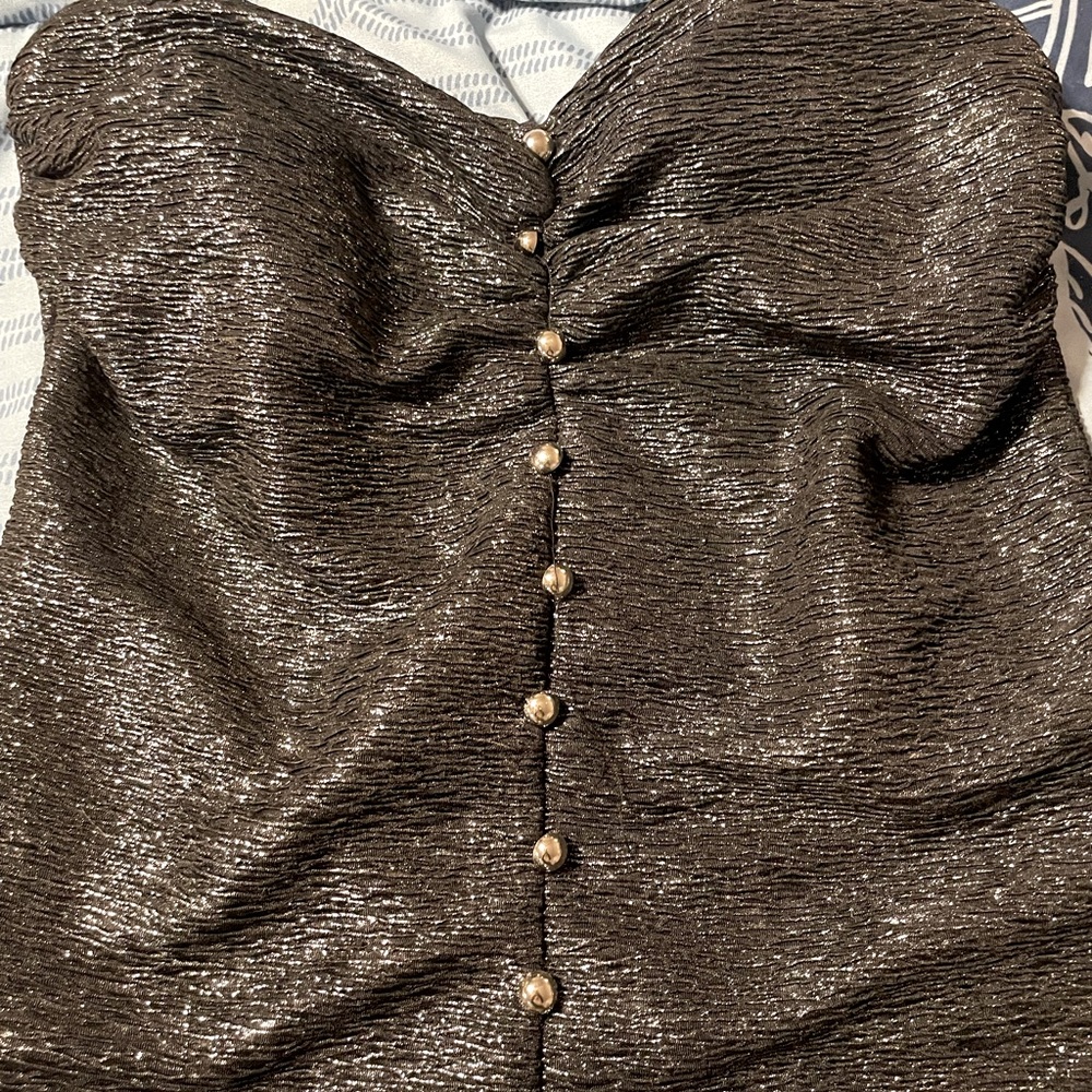 Strapless black shimmer top with faux buttons down front zips up in back.